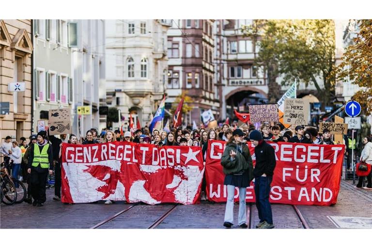 Der Demonstrationszug zieht mit Bannern mit der Aufschrift "Gen Z regelt das!" und "Gen Z Regelt Zeit für Widerstand" durch die Innenstadt von Freiburg.
