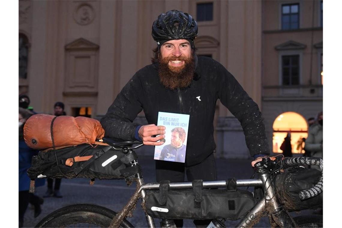 Der deutsche Extremsportler Jonas Deichmann präsentiert sein Fahrrad und sein Buch. Foto: Felix Hörhager/dpa