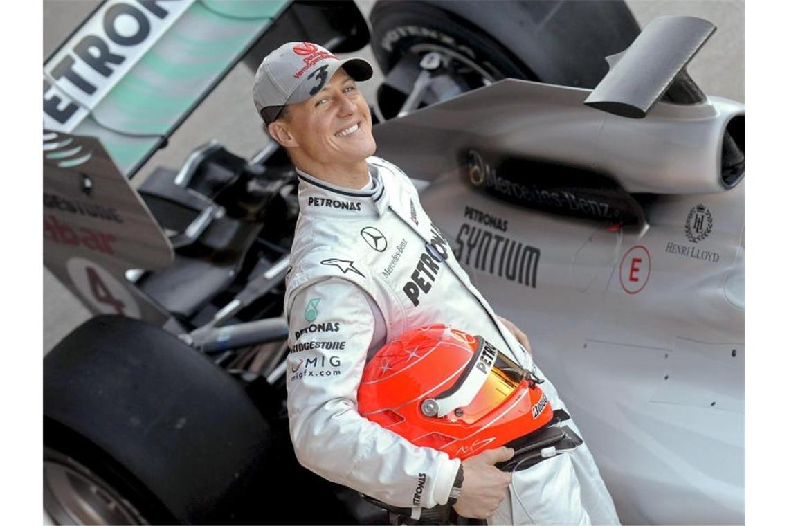 Der deutsche Formel-1-Pilot Michael Schumacher posiert 2010 neben seinem Mercedes-Rennwagen. Foto: Kai Försterling/epa efe/dpa