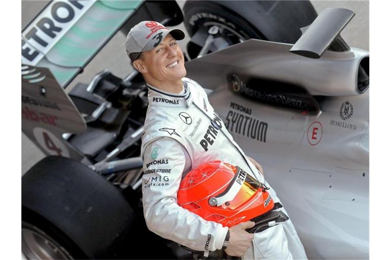 Der deutsche Formel-1-Pilot Michael Schumacher posiert 2010 neben seinem Mercedes-Rennwagen. Foto: Kai Försterling/epa efe/dpa