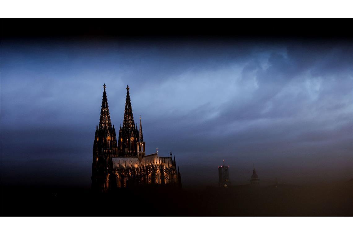 Bilder des Tages Der Dom in Köln ist am Morgen durch ein Geländer gesehen beleuchtet.