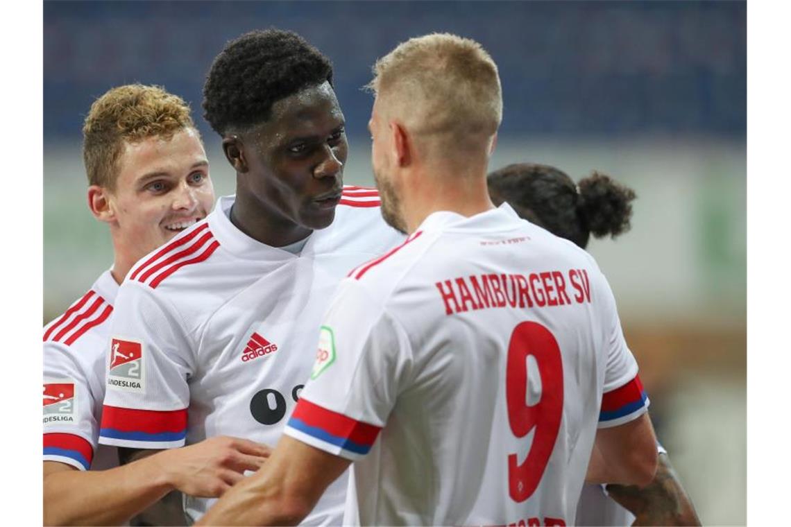 Der doppelte HSV-Torschütze Simon Terodde (r) freut sich mit seinen Teamkollegen. Foto: Friso Gentsch/dpa