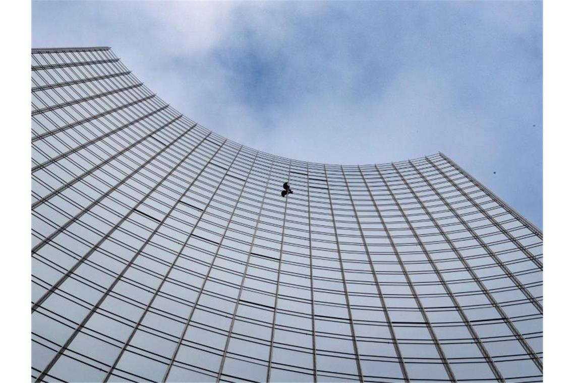Der Extremkletterer Alain Robert klettert ungesichert an der Fassade der Skyper-Hochhauses in die Höhe. Foto: Boris Roessler
