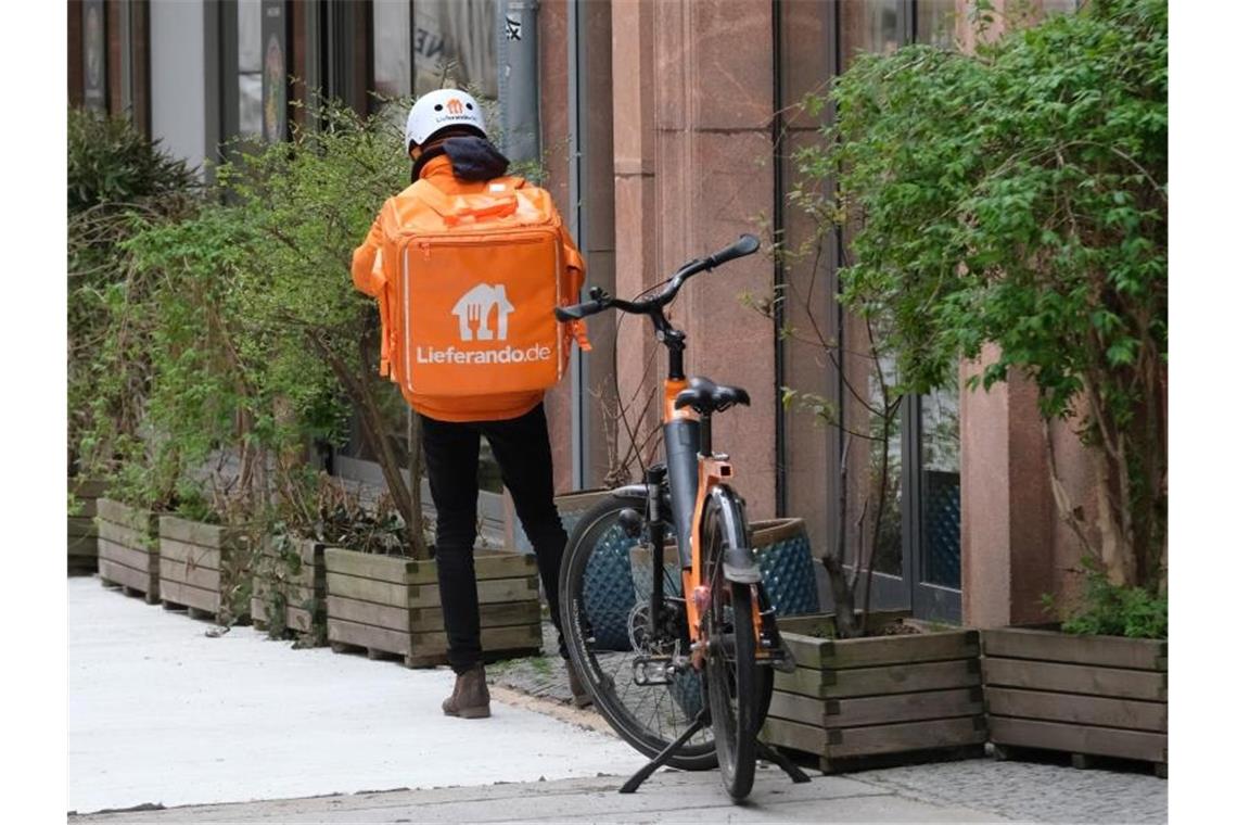 Der Fahrer eines Lieferdienstes wartet vor einem Restaurant im Zentrum der Stadt. Foto: Sebastian Willnow/dpa-Zentralbild/dpa