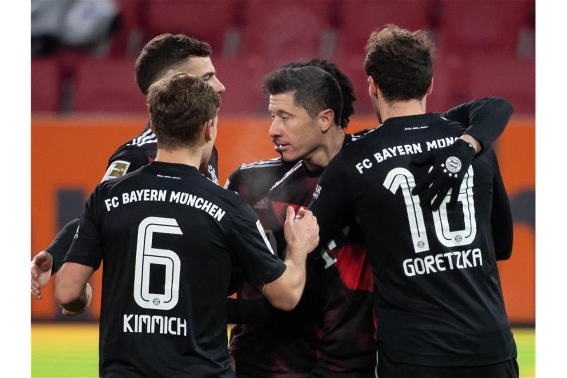 FCB und RB siegen mit Mühe - Schalke verliert Kellerduell Der FC Bayern München setzte sich auch dank Torjäger Robert Lewandowski (M.) knapp in Augsburg durch. Foto: Sven Hoppe/dpa