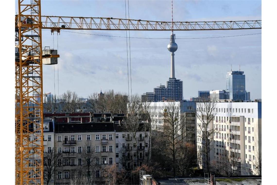 Der Fernsehturm am Alexanderplatz ist hinter Baukränen und Mietshäusern zu sehen. Als erstes Bundesland führt Berlin den Mietendeckel ein. Foto: Jens Kalaene/dpa-Zentralbild/dpa/Archiv