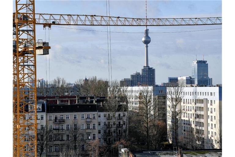 Der Fernsehturm am Alexanderplatz ist hinter Baukränen und Mietshäusern zu sehen. Als erstes Bundesland führt Berlin den Mietendeckel ein. Foto: Jens Kalaene/dpa-Zentralbild/dpa/Archiv