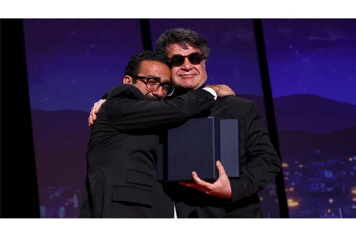 Jafar Panahi geehrt – Cannes politisch wie lange nicht Der Filmemacher Vahid Mobseri umarmt Jafar Panahi bei der Preisverleihung.
