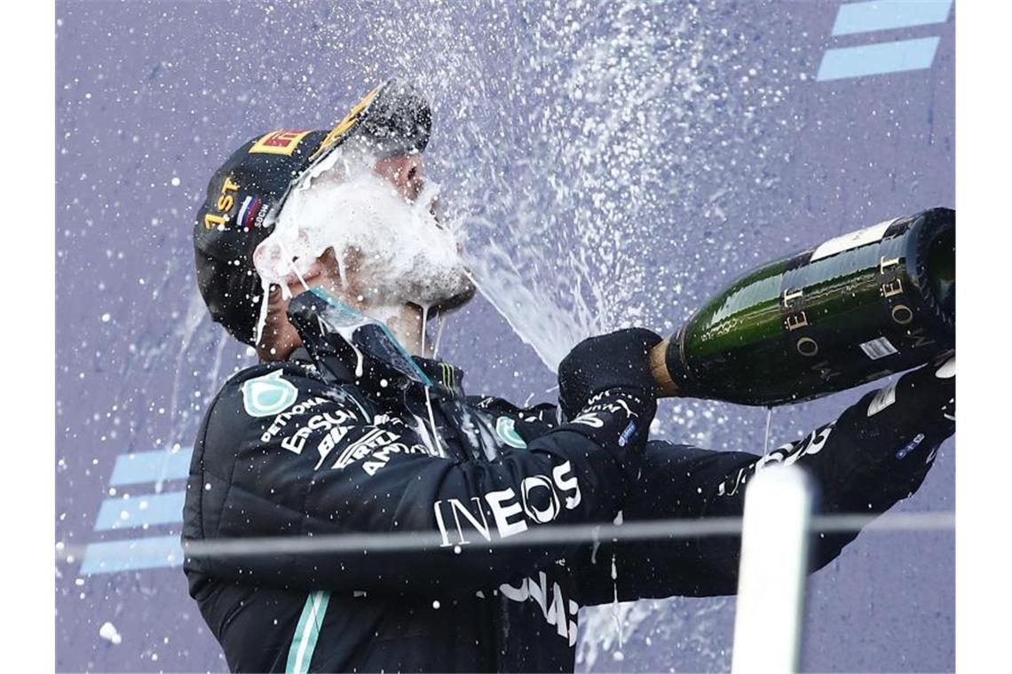 Der finnische Mercedes-Pilot feierte seinen Sieg mit Champagner. Foto: Maxim Shemetov/Pool Reuters/AP/dpa