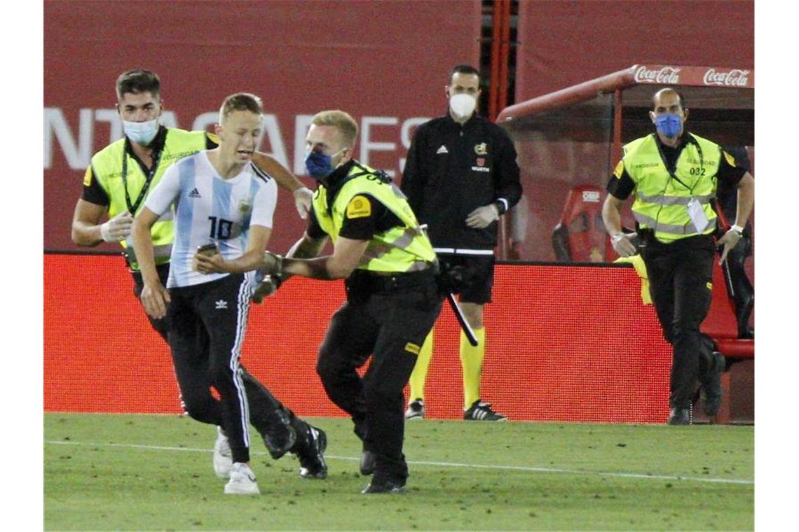 Der Flitzer wurde geschnappt, bevor er ein Foto mit Barcelonas Star Lionel Messi machen konnte. Foto: Francisco Ubilla/AP/dpa