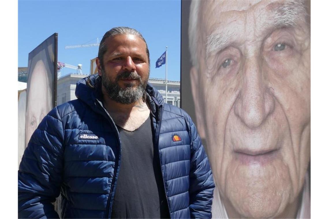 Der Fotograf Luigi Toscano steht vor dem Porträt des Holocaust-Überlebenden Sol Farkas. Foto: Barbara Munker/dpa/Archivbild