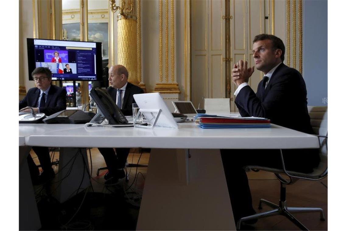 Der französische Präsident Emmanuel Macron nimmt im Élysée-Palast an der Internet-Konferenz teil. Foto: Gonzalo Fuentes/POOL Reuters/AP/dpa