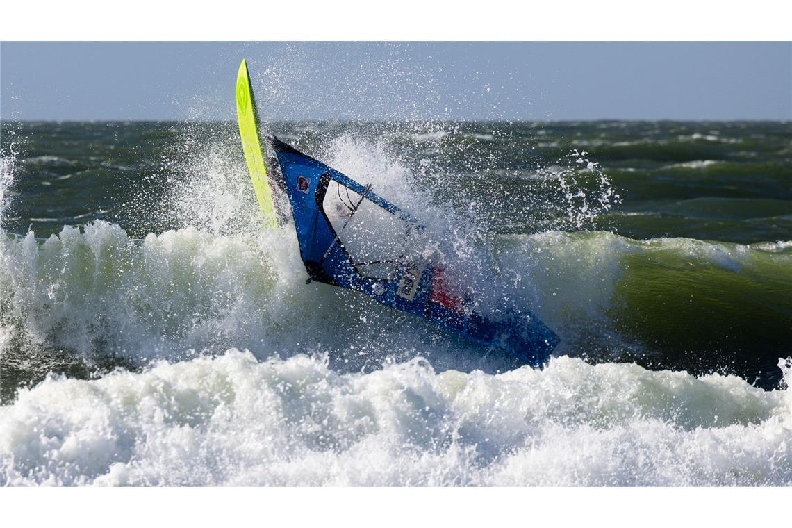 Der französische Windsurfer Antoine Martin stürzt nach einem Sprung im Shorebreak während des Windsurf World Cups auf Sylt.