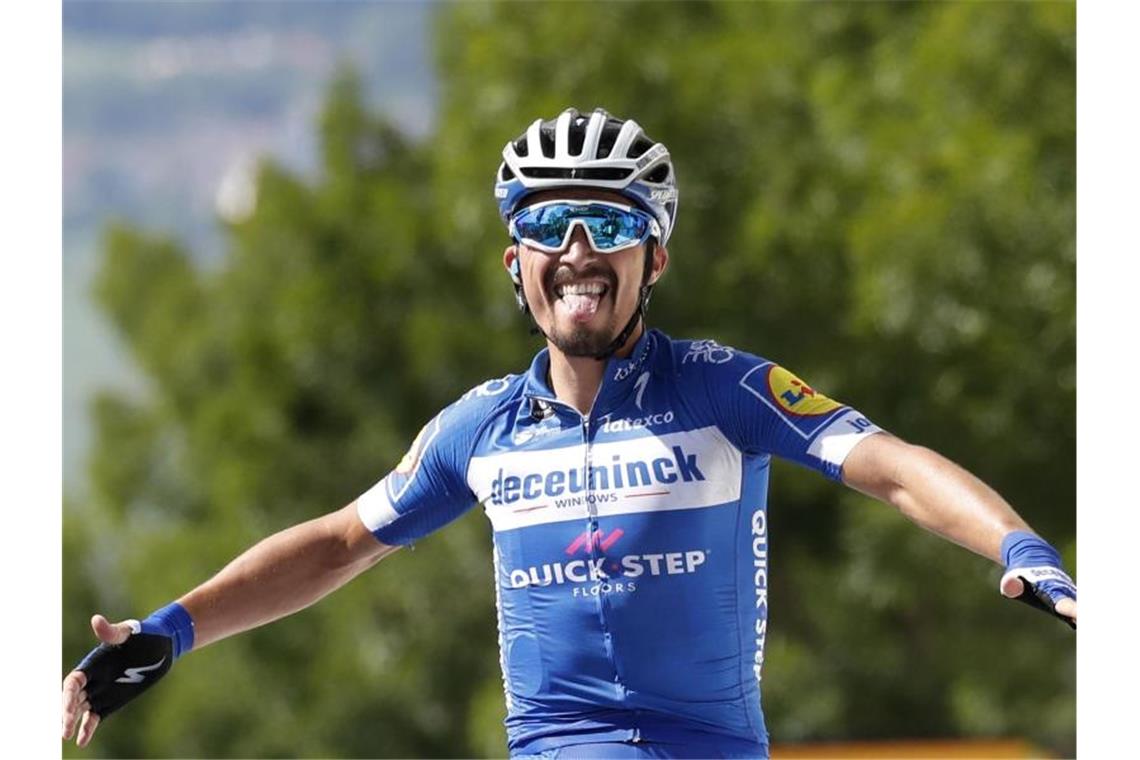 Höllenritt: Franzose Alaphilippe krönt starkes Solo mit Gelb Der Franzose Julian Alaphilippe bejubelt seinen Etappensieg bei der Zieleinfahrt. Foto: Christophe Ena/AP