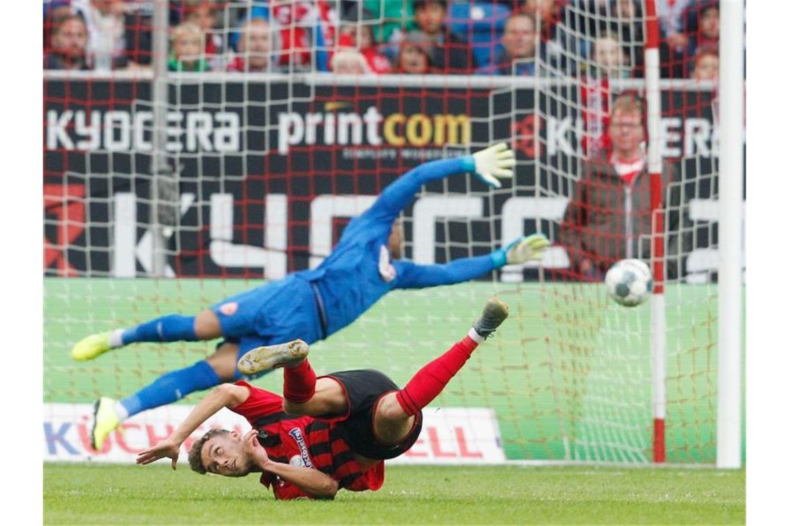 Der Freiburger Gian Luca Waldschmidt (unten) hat gegen Düsseldorfs Torwart Zackary Steffen das Tor zum 2:1-Sieg erzielt. Foto: Roland Weihrauch