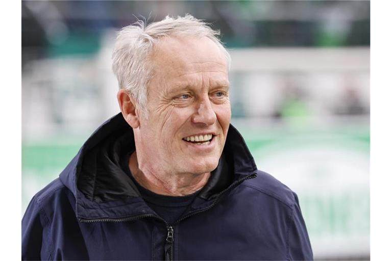 Der Freiburger Trainer Christian Streich lächelt im Interview. Foto: Daniel Löb/dpa