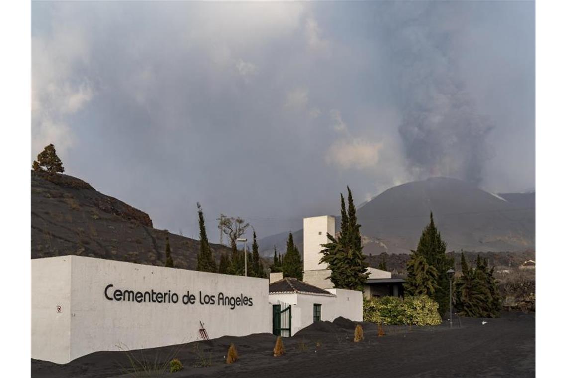 Flugverbindung nach La Palma unterbrochen Der Friedhof von Los Angeles ist mit Asche bedeckt, während im Hintergrund die Rauch- und Aschesäule zu sehen ist, die der Vulkan Cumbre Vieja ausstößt. Foto: Europa Press/EUROPA PRESS/dpa