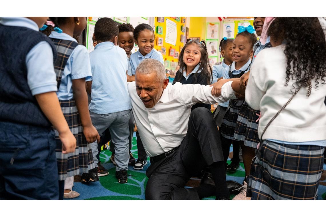 Der frühere US-Präsident Barack Obama lässt sich beim Aufstehen von Kindern hochheben.