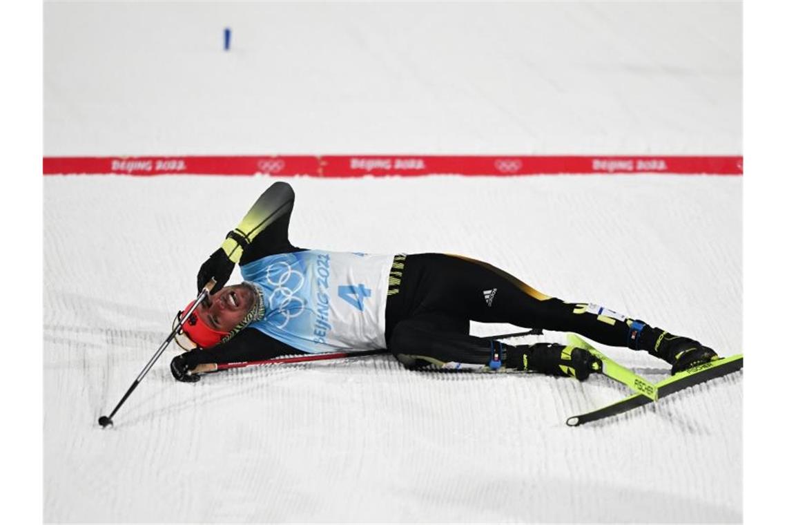 Kombinierer Geiger düpiert Rivalen - Mit Turbofinish zu Gold Der fünftplatzierte Johannes Rydzek liegt nach dem Rennen entkräftet am Boden. Foto: Hendrik Schmidt/dpa