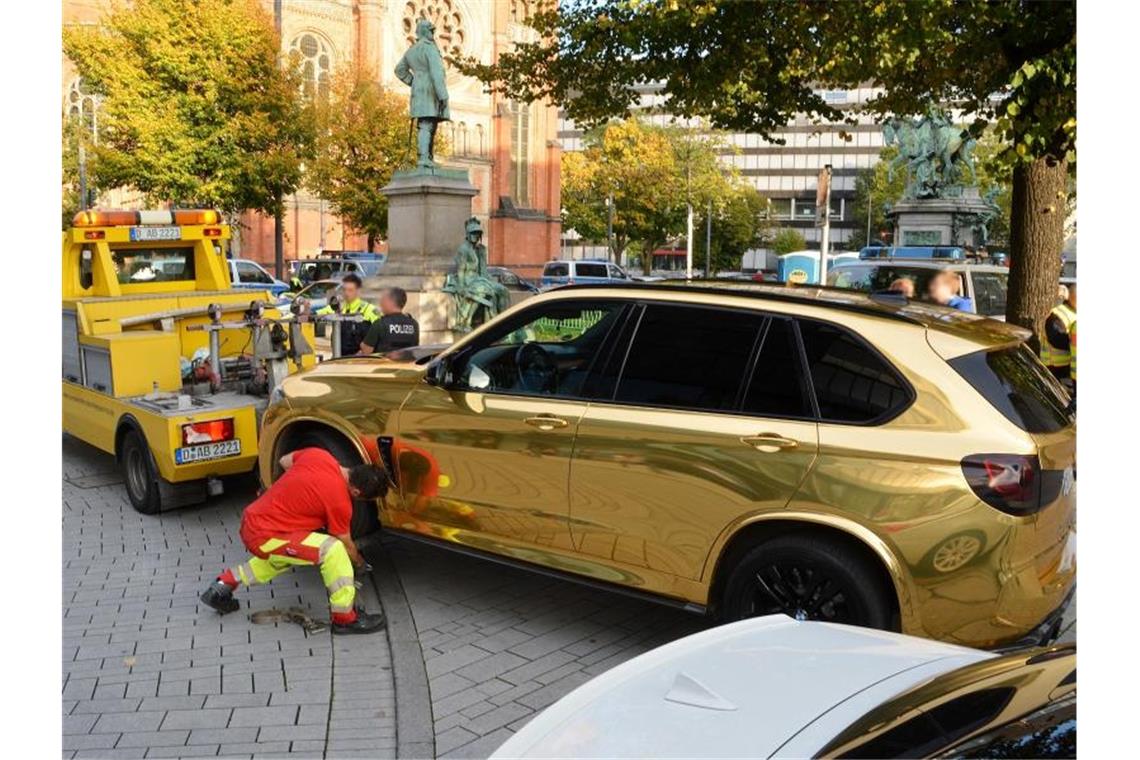 Der goldfarbene SUV wird nahe der Düsseldorfer Königsallee abgeschleppt. Foto: Gerhard Berger
