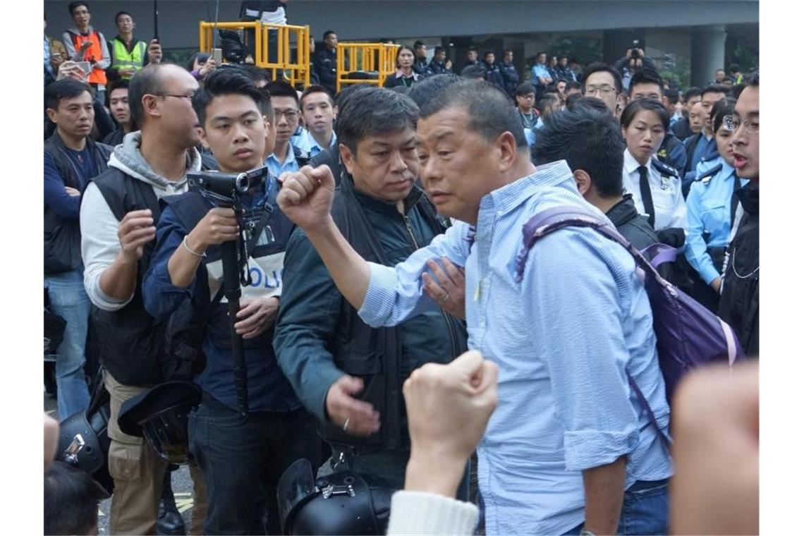 Der Gründer der großen Hongkonger Zeitung „Apple Daily“, Jimmy Lai (m.), wird von der Polizei bei einem Protest festgenommen. Foto: Str/EPA/dpa