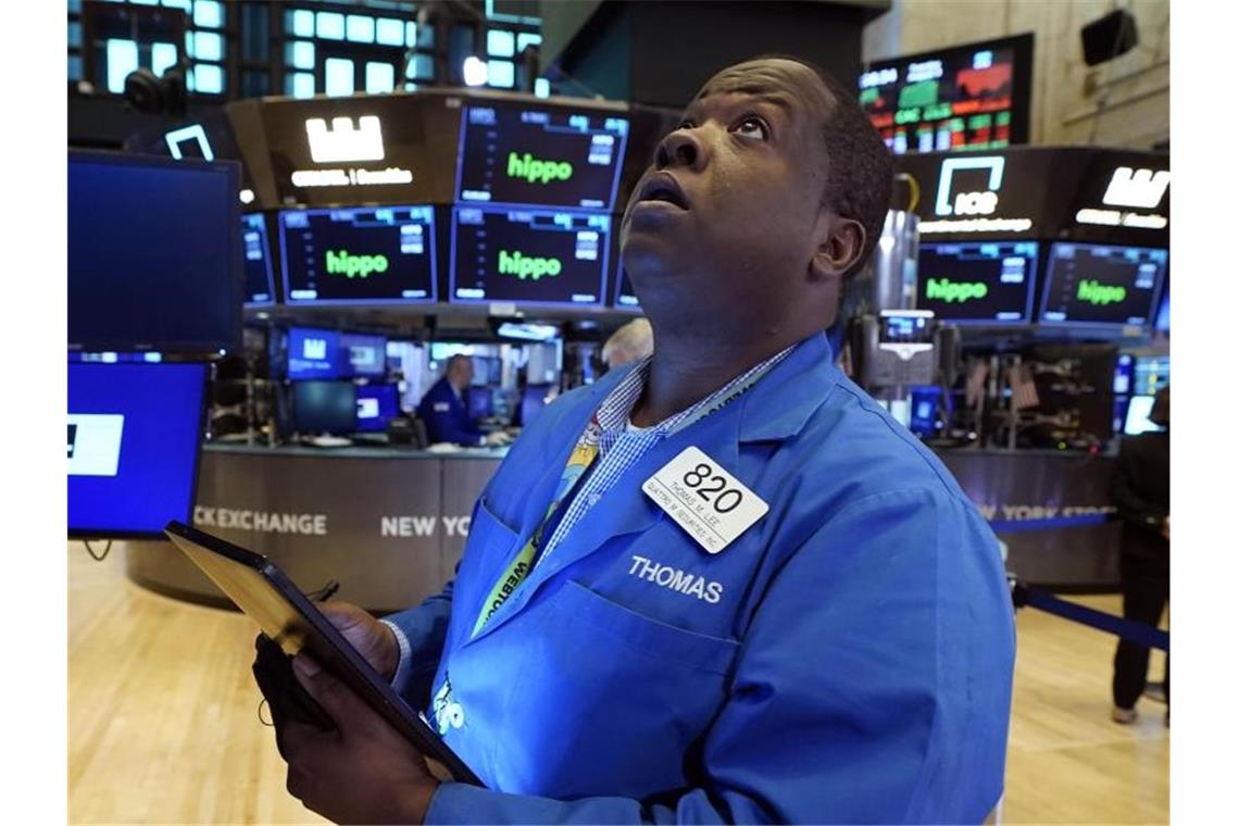 Steigende Corona-Fallzahlen verunsichern US-Investoren Der Händler Thomas Lee arbeitet auf dem Parkett der New Yorker Börse und halt dabei ein Tablet in den Händen. Foto: Richard Drew/AP/dpa