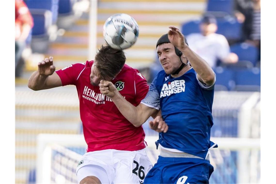 Der Hannoveraner Hendrik Weydandt und der Karlsruher Damian Roßbach (l-r.) kämpfen um den Ball. Foto: Uli Deck/dpa