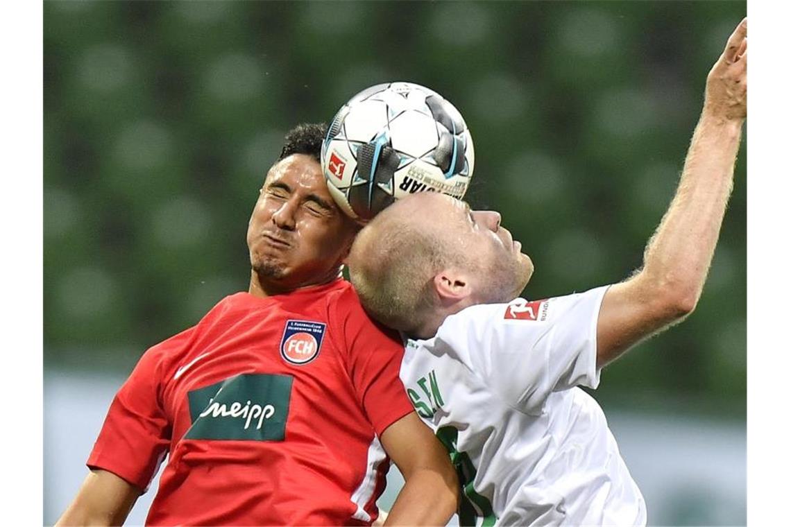 Der Heidenheimer Kevin Sessa (l) und der Bremer Davy Klaassen im Kopfballduell. Foto: Martin Meissner/AP POOL/dpa