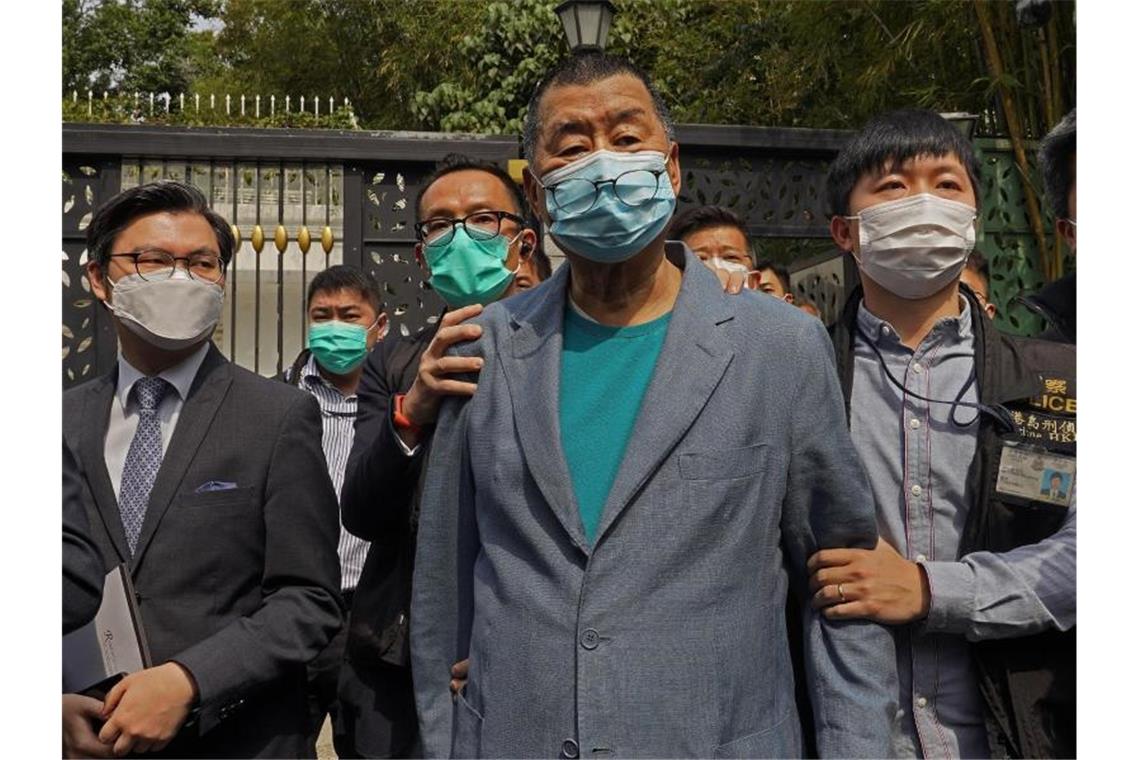 Der Hongkonger Medientycoon Jimmy Lai (M), Gründer der pro-demokratischen Lokalzeitung Apple Daily, wird nach seiner Verhaftung von Polizisten eskortiert. Foto: Vincent Yu/AP/dpa