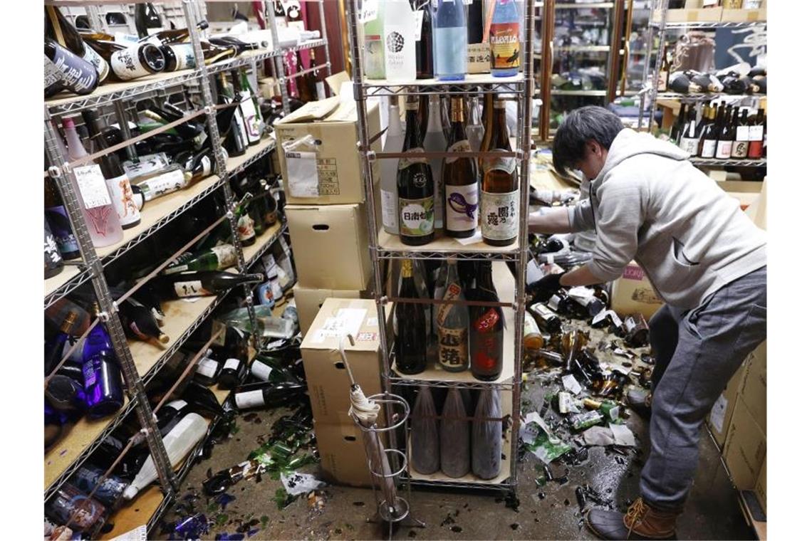 Starkes Erdbeben in Japan Der Inhaber eines Spirituosengeschäfts räumt nach einem starken Erdbeben in seinem Geschäft auf. Foto: Jun Hirata/Kyodo News/AP/dpa