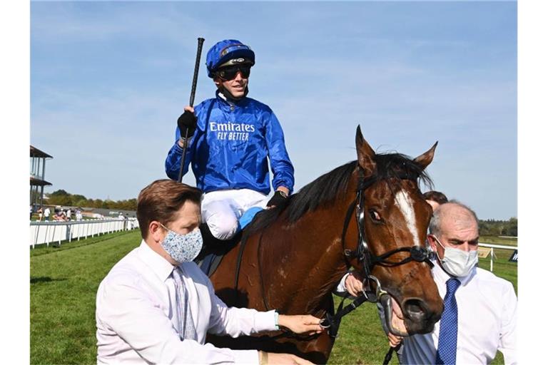 Der Jockey James Doyle (M) gewinnt mit dem Pferd Barney Roy den 148. Großen Preis von Baden. Foto: Uli Deck/dpa