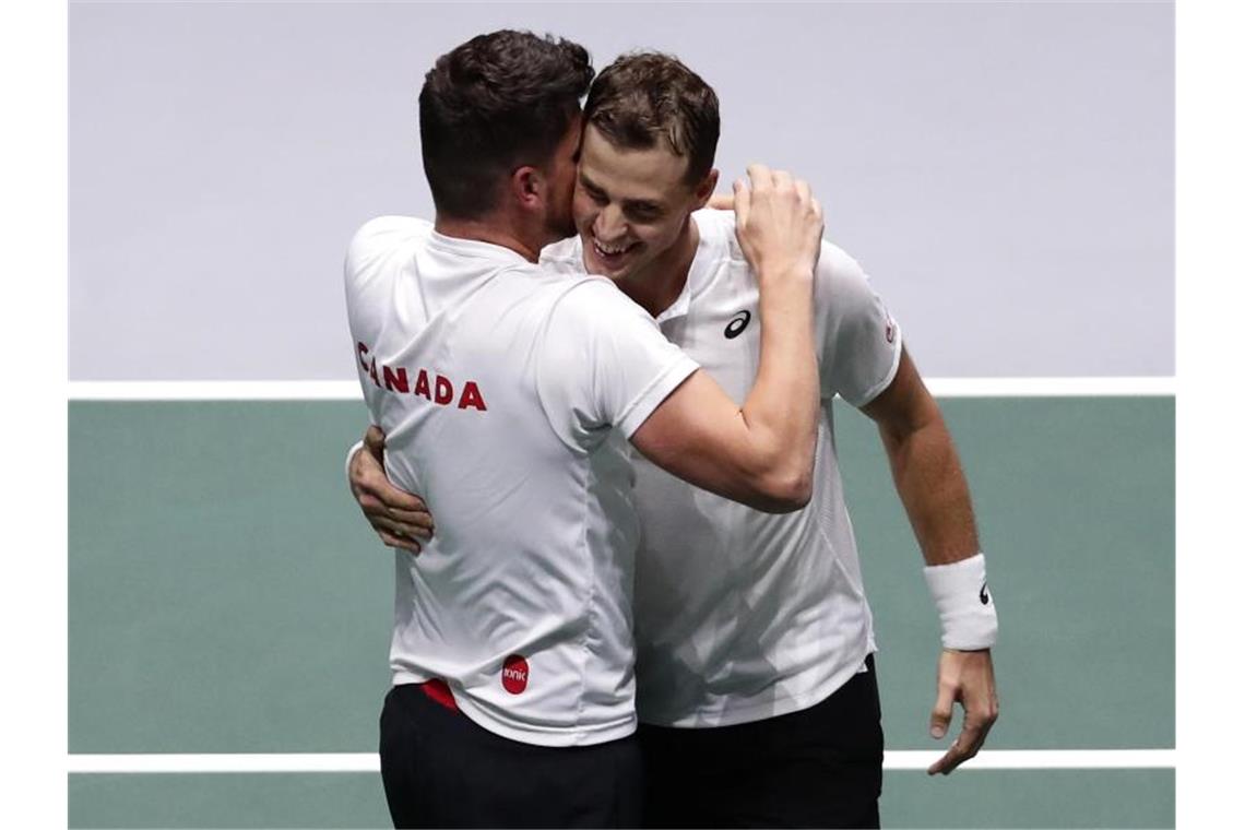 Der Kanadier Vasek Pospisil (r) feiert seinen Sieg mit Kapitän Frank Dancevic. Foto: Manu Fernandez/AP/dpa