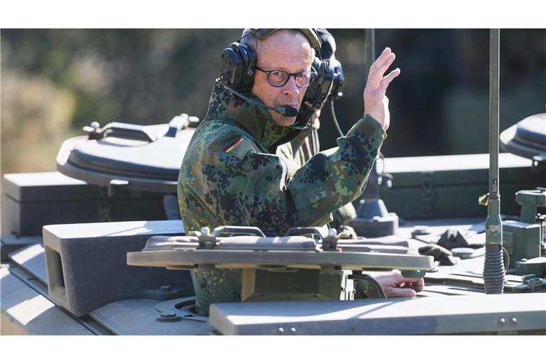 Der Kanzler grüßt aus einem gepanzerten Fahrzeug beim Truppenbesuch in Munster.