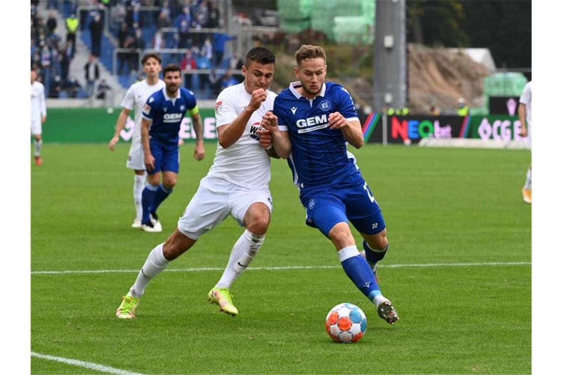 Der Karlsruher Christoph Kobald (r) und der Auer Antonio Jonjic kämpfen um den Ball. Foto: Uli Deck/dpa