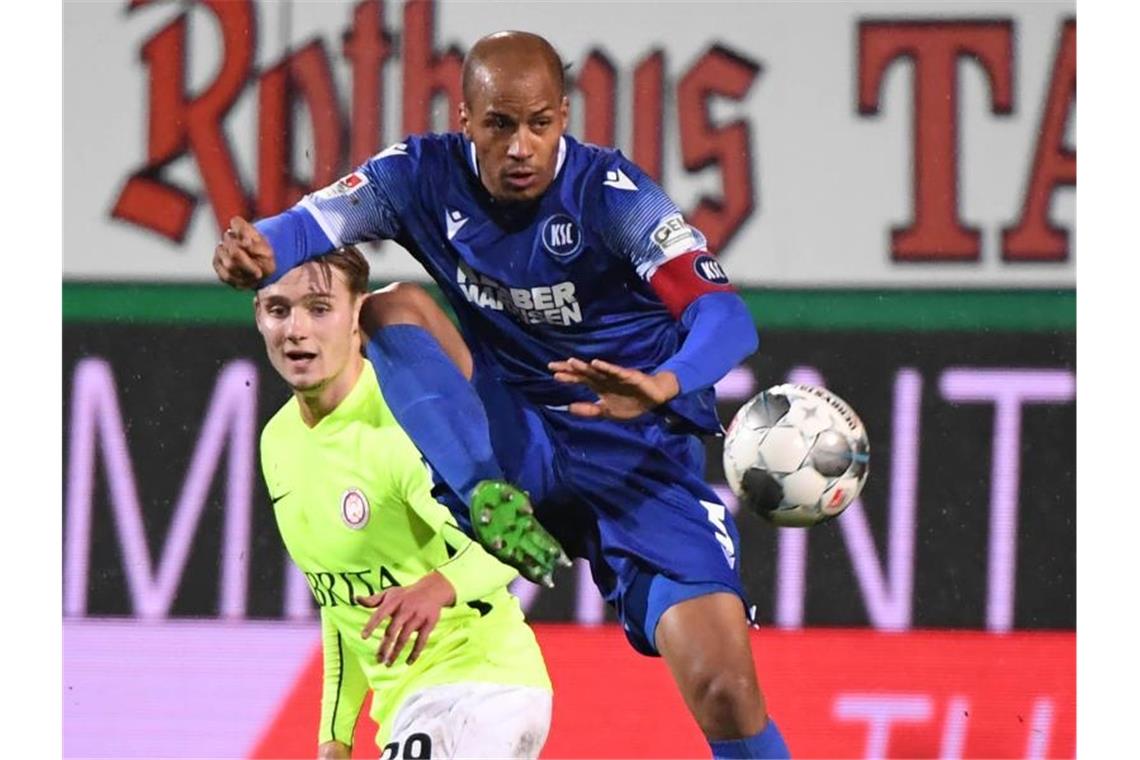 Der Karlsruher David Pisot nimmt den Ball vor dem Wiesbadener Törles Knöll an. Foto: Uli Deck/dpa