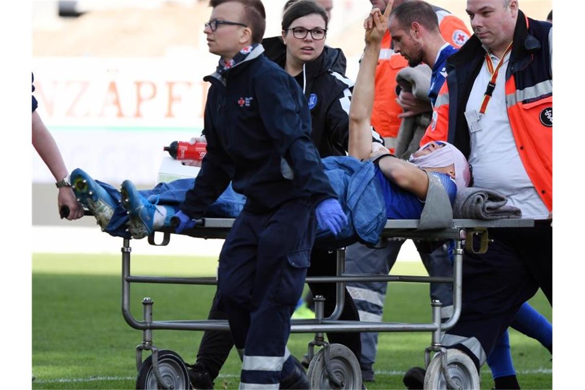 KSC-Profi Carlson mit Kopfwunde ins Krankenhaus Der Karlsruher Dirk Carlson wird verletzt vom Platz gebracht. Foto: Uli Deck/dpa