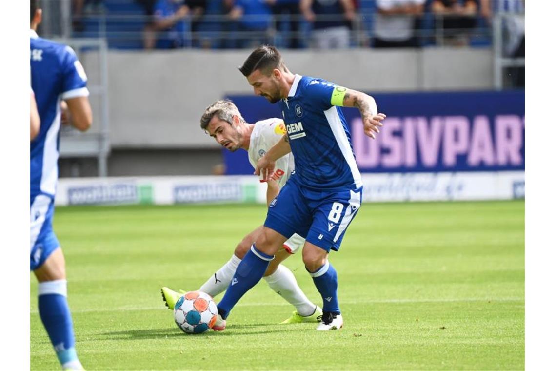 Der Karlsruher Jerome Gondorf (r) und der Kieler Fin Bartels kämpfen um den Ball. Foto: Uli Deck/dpa/archivbild