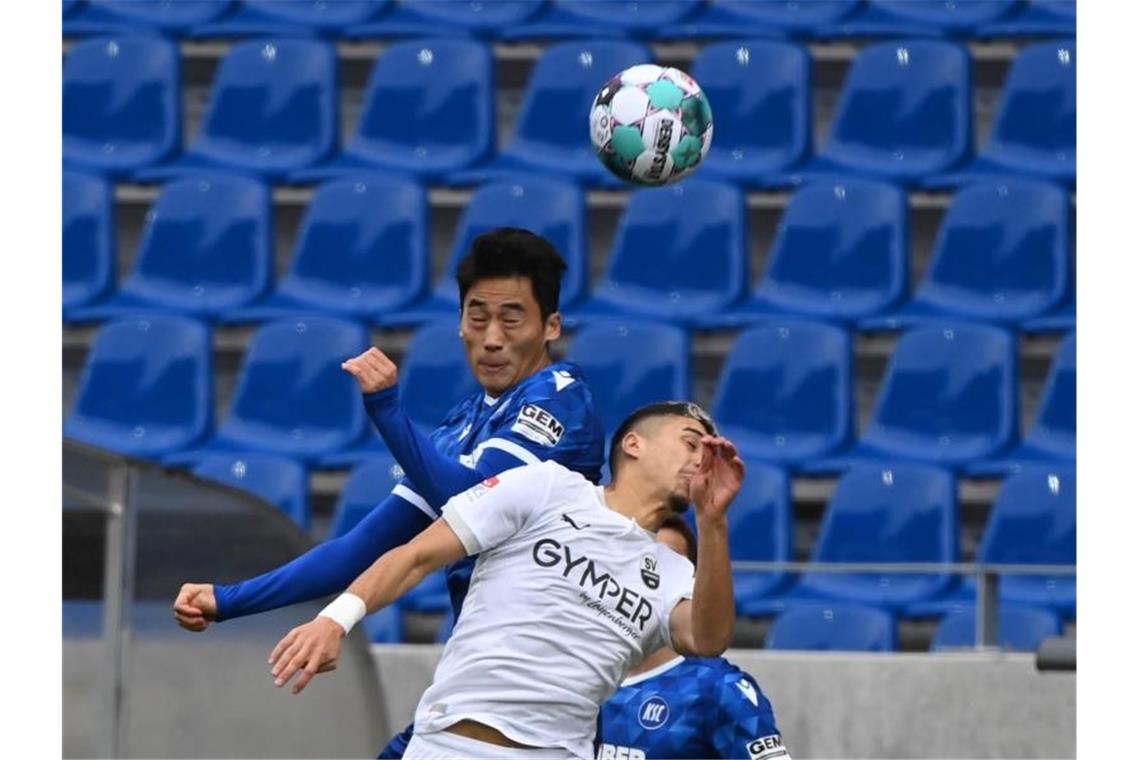 Die Hoffnung ist zurück: Beim KSC und seinem Knipser Hofmann Der Karlsruher Kyoung-rok Choi und der Sandhausener Anas Quahim (l-r.) in Aktion. Foto: Uli Deck/dpa