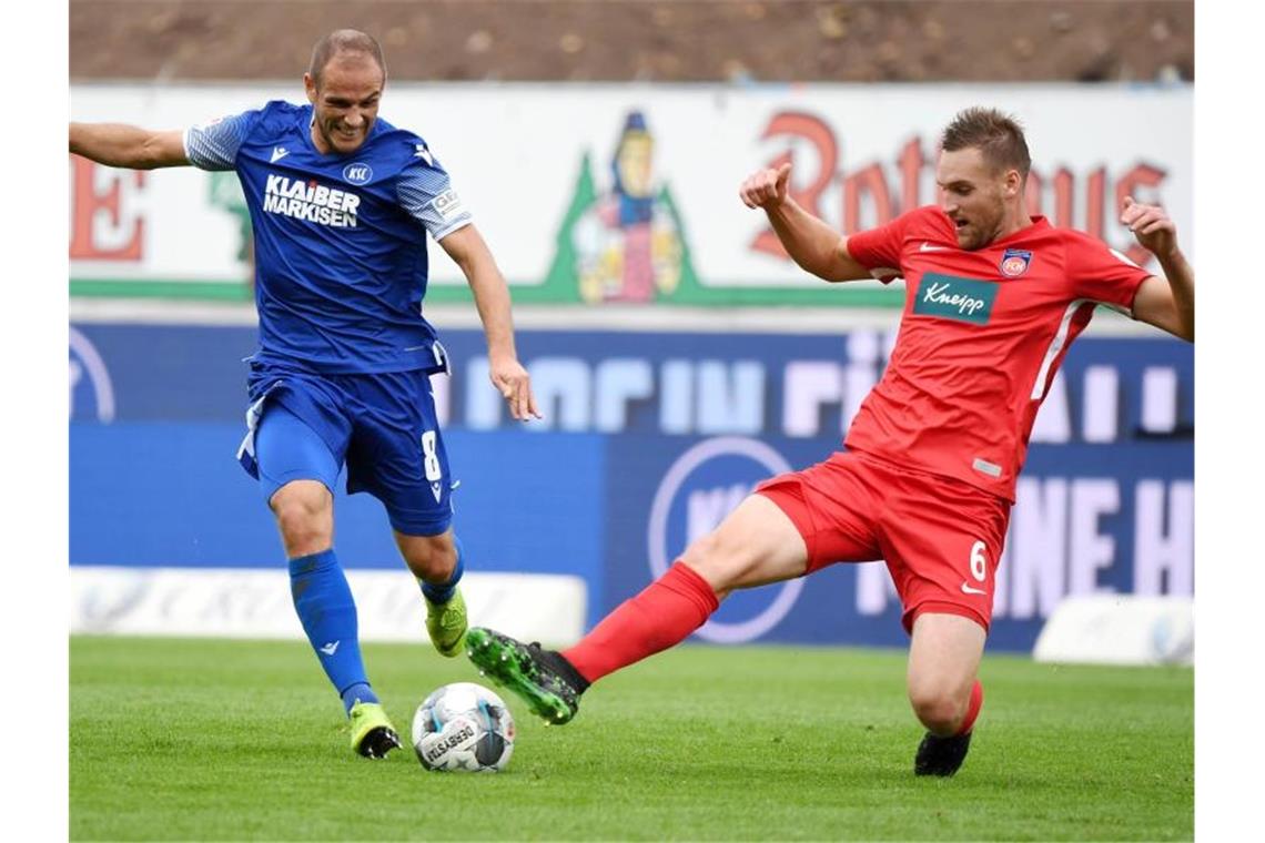 Auf Kurs: KSC sammelt weiter Punkte gegen den Abstieg Der Karlsruher Manuel Stiefler und der Heidenheimer Patrick Mainka (l-r.) im Zweikampf um den Ball. Foto: Uli Deck