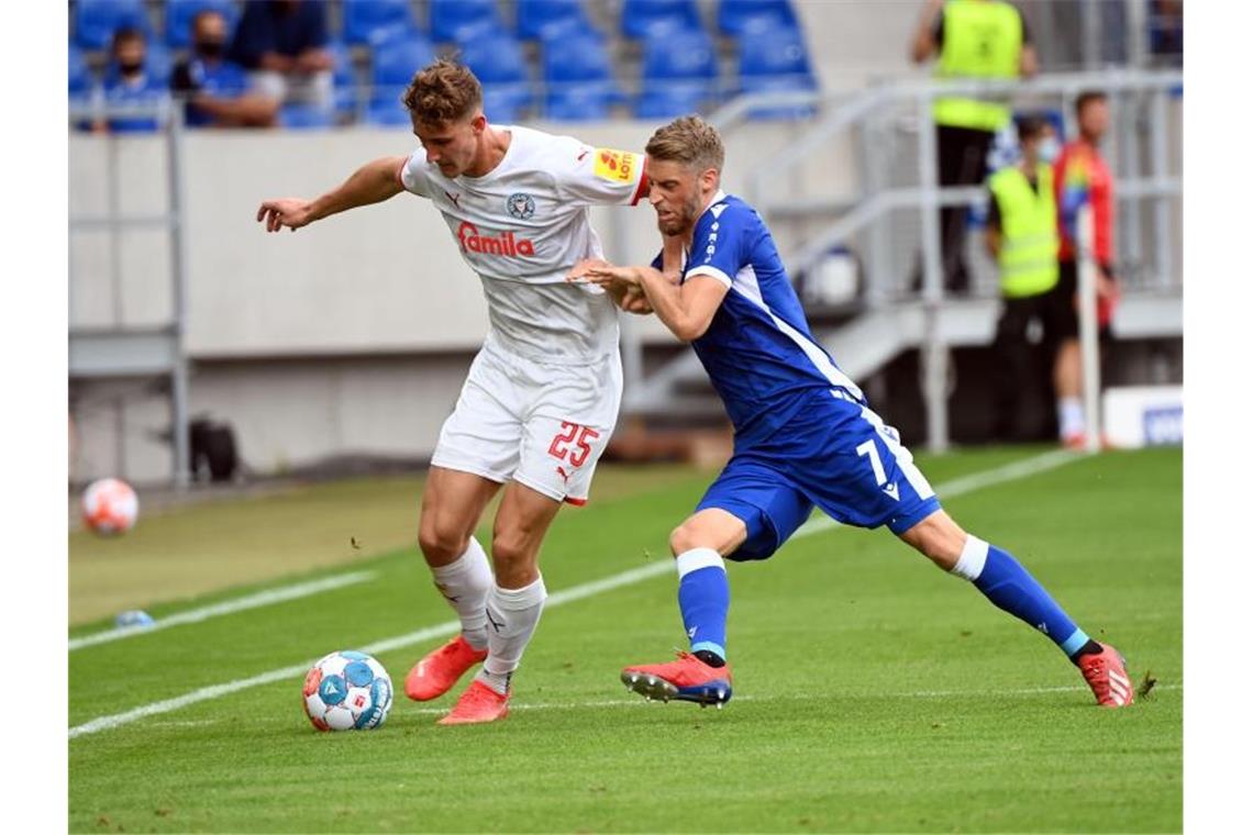 Bremen feiert nächsten Sieg - Späte Tore in Karlsruhe Der Karlsruher Marc Lorenz (r) und der Kieler Phil Yannik Neumann kämpfen um den Ball. Foto: Uli Deck/dpa