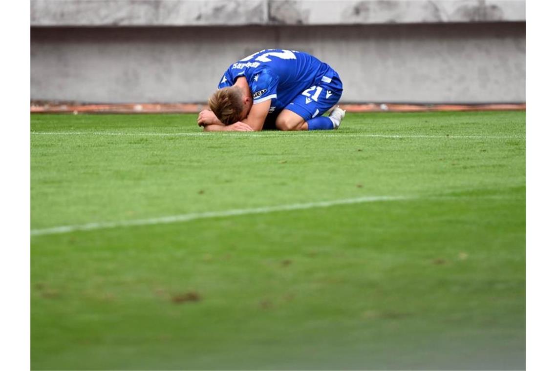Der Karlsruher Marco Thiede liegt nach der 0:1 Niederlage auf dem Platz. Foto: Uli Deck/dpa