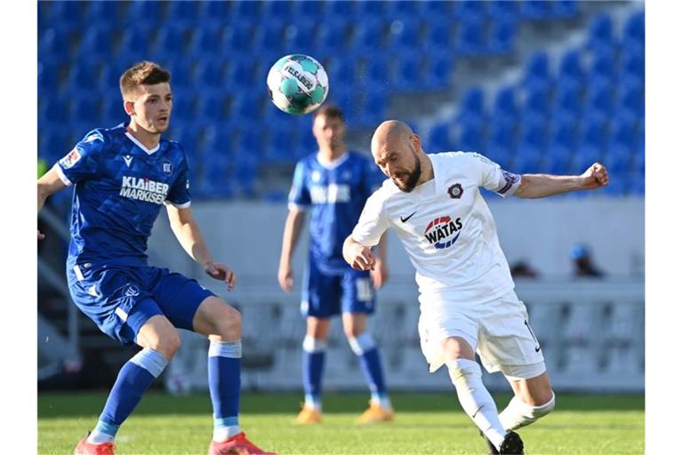 Der Karlsruher Marvin Wanitzek (l) und der Auer Philipp Riese kämpfen um den Ball. Foto: Uli Deck/dpa