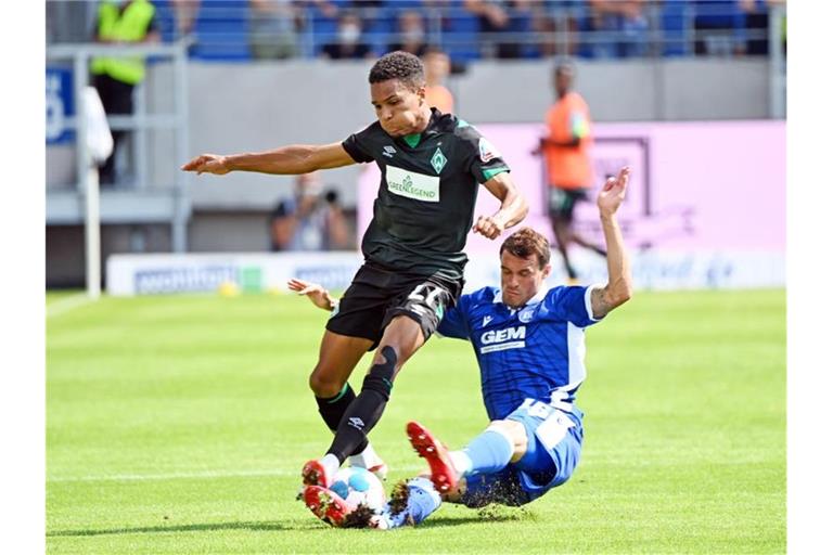 Der Karlsruher Philip Heise (r) und der Bremer Felix Agu kämpfen um den Ball. Foto: Uli Deck/dpa