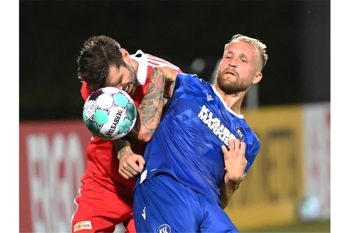 Der Karlsruher Philipp Hofmann (r) und der Berliner Christopher Trimmel kämpfen um den Ball. Foto: Uli Deck/dpa/Archivbild