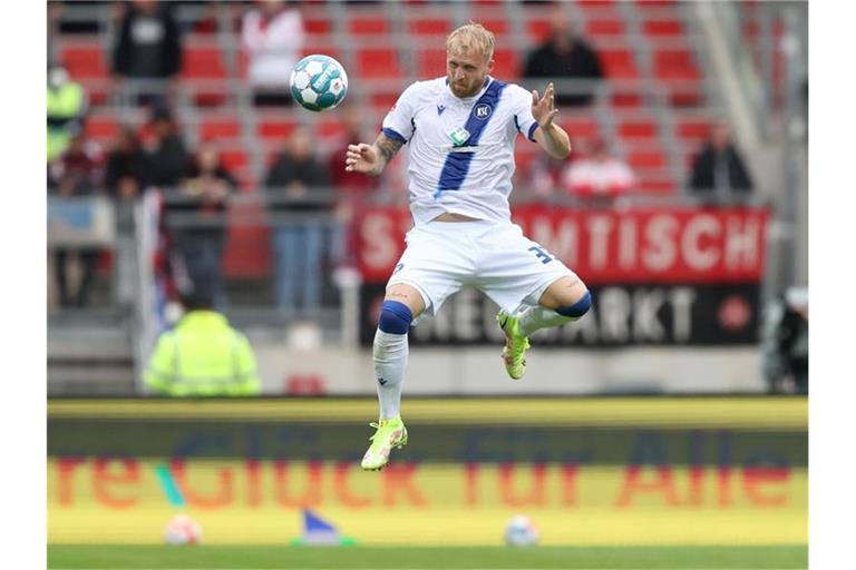 Der Karlsruher Philipp Hofmann spielt den Ball. Foto: Daniel Karmann/dpa/Archiv