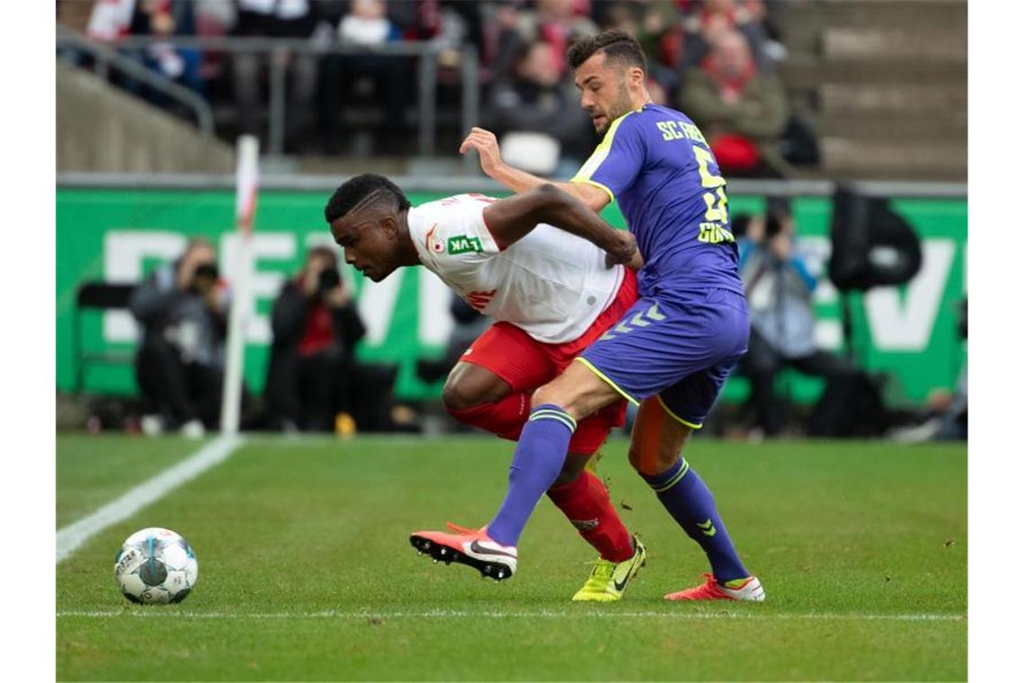 Der Kölner Jhon Cordoba (l.) und der Freiburger Manuel Gulde kämpfen um den Ball. Foto: Federico Gambarini/dpa