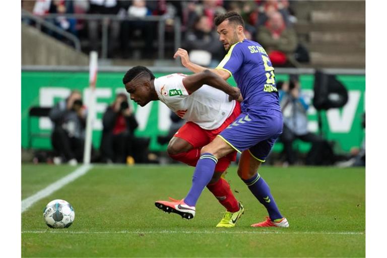 Der Kölner Jhon Cordoba (l.) und der Freiburger Manuel Gulde kämpfen um den Ball. Foto: Federico Gambarini/dpa