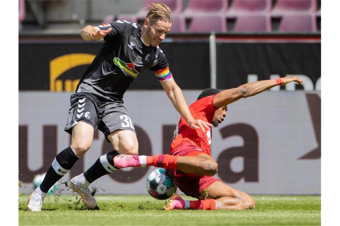 Duda wie einst Beckham: Bitterer Nackenschlag für Köln Der Kölner Kingsley Ehizibue (r) geht im Zweikampf mit Christian Günter zu Boden. Foto: Rolf Vennenbernd/dpa