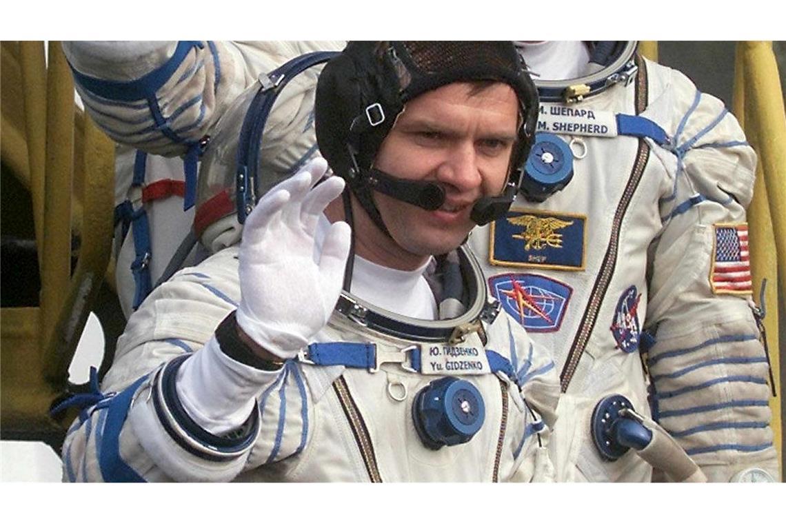 "Unwahrscheinlichste Maschine": 25 Jahre Crew auf der ISS Der Kommandant der ersten Langzeitmission zur Internationalen Raumstation, der amerikanische Astronaut Bill Shepherd (M), und die russischen Kosmonauten Juri Gidsenko (unten) und Sergej Krikaljow (oben) winken, bevor sie auf dem Kosmodrom in das Raumschiff "Sojus-TM-31" einsteigen. (Archivbild)