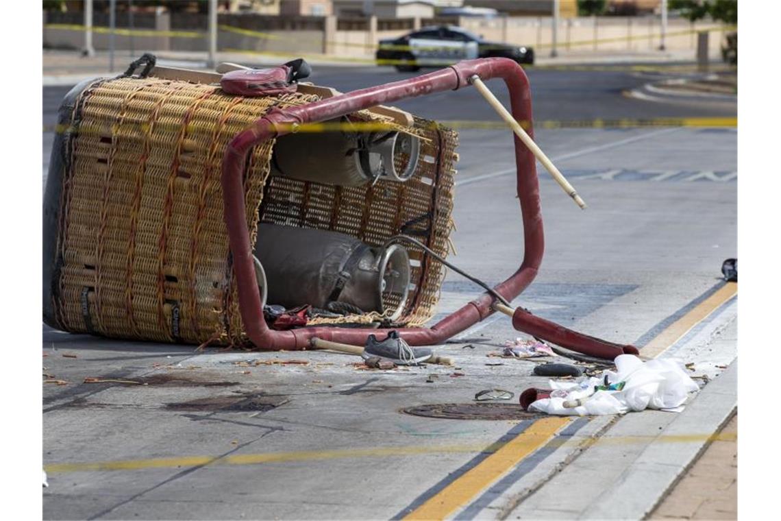 Fünf Tote bei Absturz von Heißluftballon in New Mexico Der Korb eines abgestürzten Heißluftballons liegt auf dem Bürgersteig einer belebte Straße in Albuquerque. Insgesamt starben fünf Insassen. Foto: Andres Leighton/AP/dpa